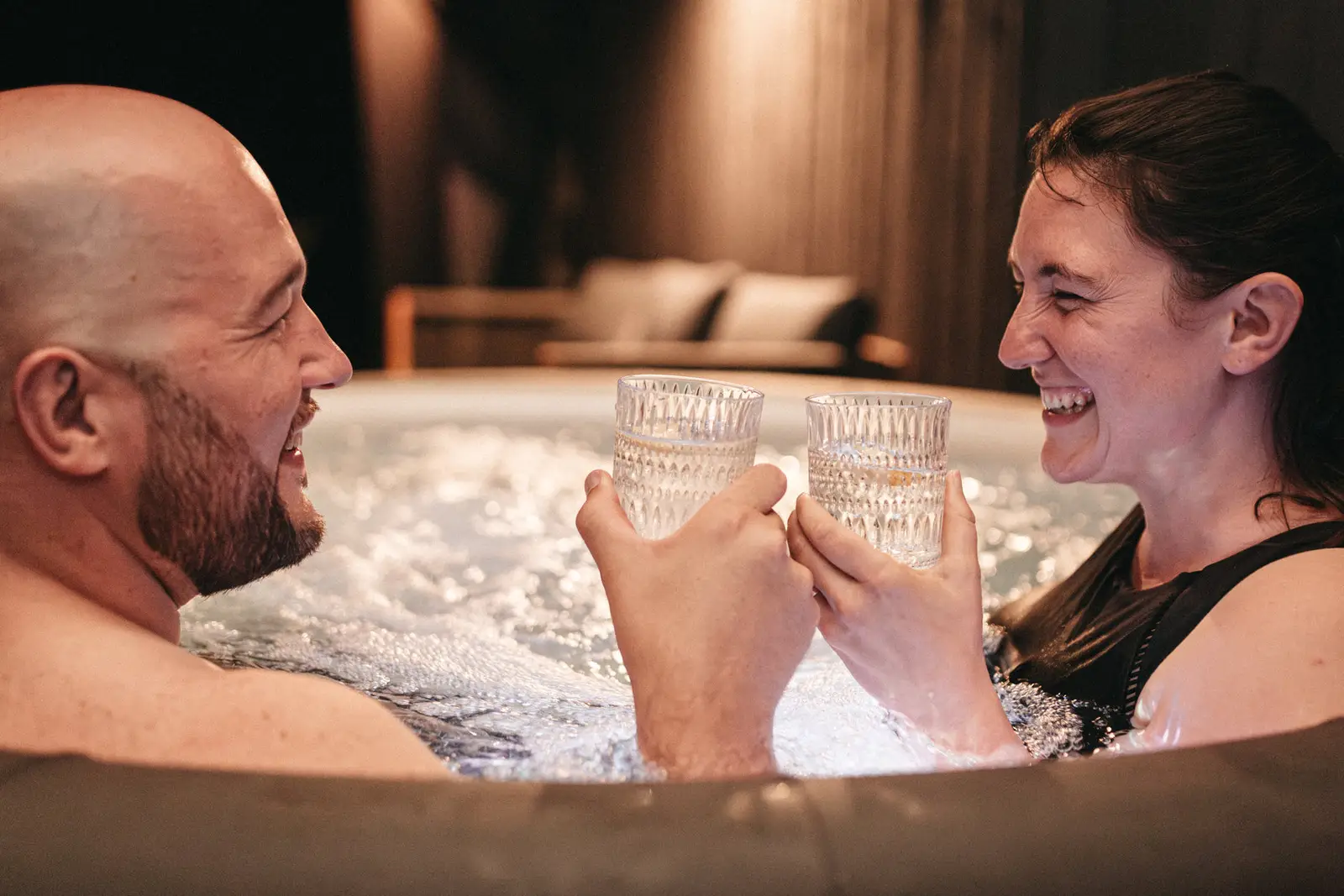 Paar stößt im warmen Whirlpool an