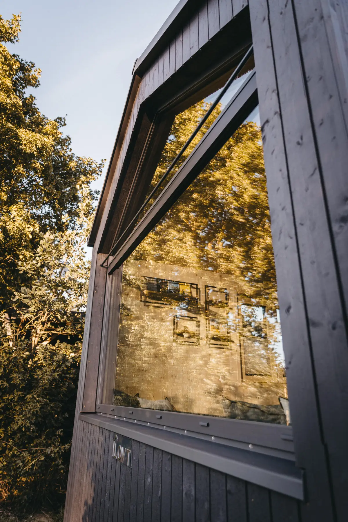 Dunkle Holzfassade einer Cabin mit Panoramafenster